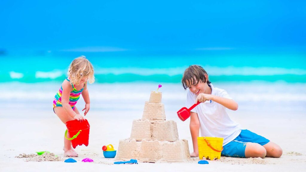 Enfants qui font un château de sable 